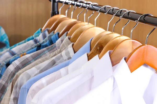 Men's shirts on hangers in wardrobe — Stock Photo, Image