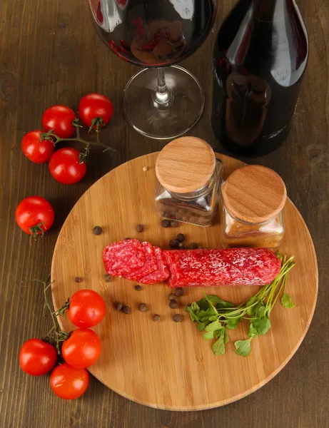 Sabroso salami a bordo mesa de madera de cerca — Foto de Stock