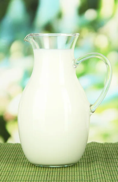 Pitcher of milk on table on bright background — Stock Photo, Image