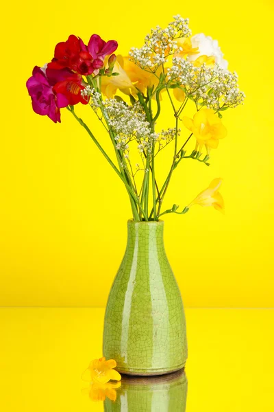 Beau bouquet de freesia en vase sur fond jaune — Photo