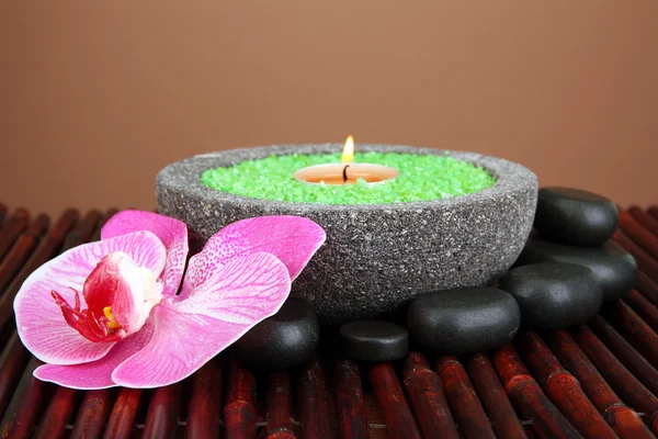 Kerze in Steinschale mit Meersalz, auf Bambusmatte, auf braunem Hintergrund — Stockfoto