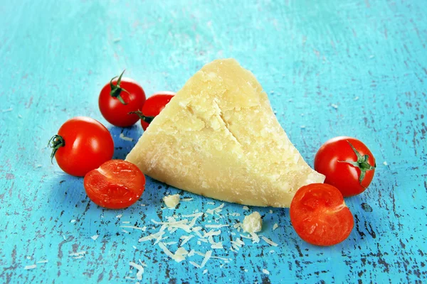 Pedaço de queijo parmesão em mesa azul de madeira close-up — Fotografia de Stock