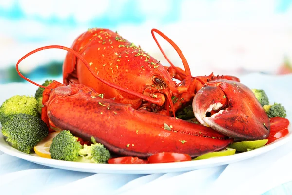 Red lobster on platter with vegetables on table close-up Royalty Free Stock Photos