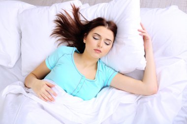 Yatakta uyuyan güzel genç kadın.