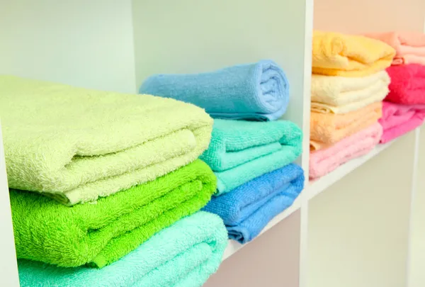 Bunte Handtücher in den Regalen im Badezimmer — Stockfoto