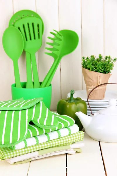 Kitchen settings: utensil, potholders, towels and else on wooden table — Stock Photo, Image