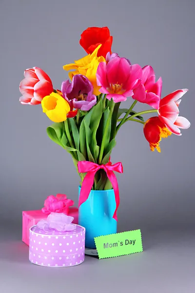 Indah tulip di buket dengan hadiah dan catatan di latar belakang abu-abu — Stok Foto