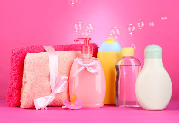 Детская косметика и полотенца на розовом фоне — стоковое фото