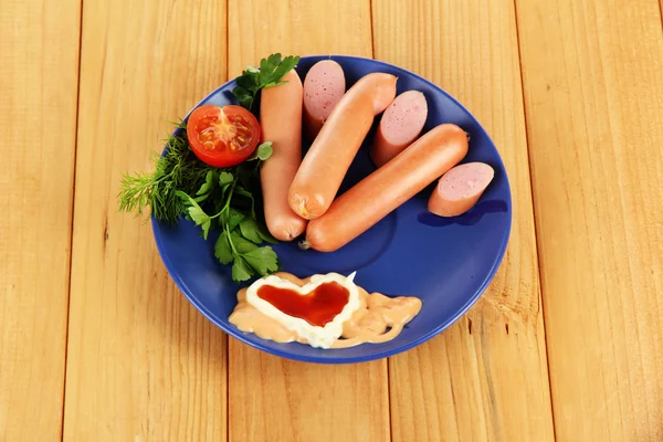 Embutidos, verduras, tomate en plato sobre mesa de madera — Foto de Stock