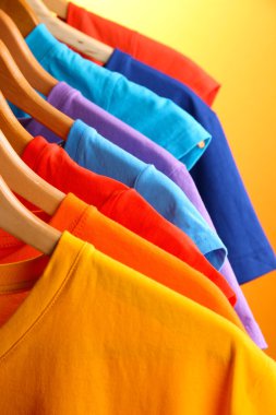 t-shirt bir sürü askıları turuncu zemin üzerinde