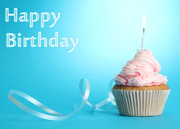 Cupcake d'anniversaire savoureux avec bougie, sur fond bleu — Photo