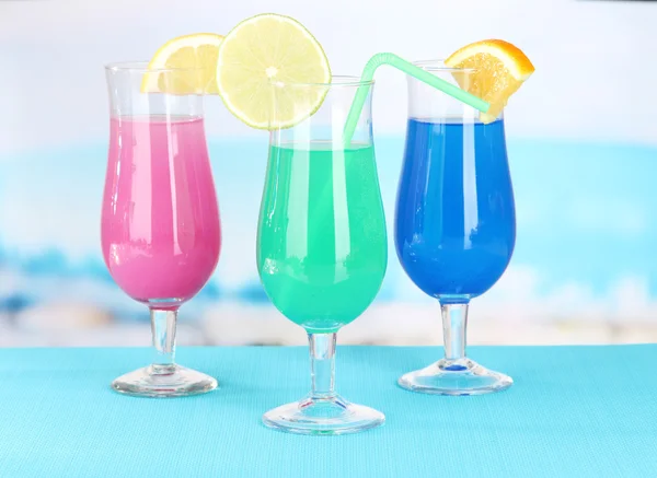 Glasses of cocktails on table near pool — Stock Photo, Image