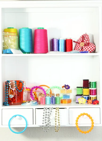 Beautiful white shelves with thread and material for handicrafts — Stock Photo, Image