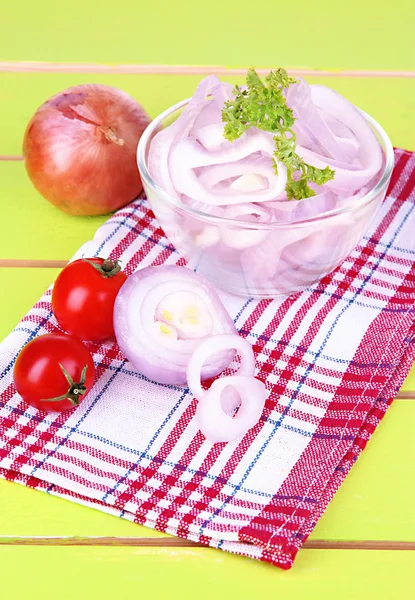 Onion cut with rings in bowl on wooden table close-up — Stock Photo, Image