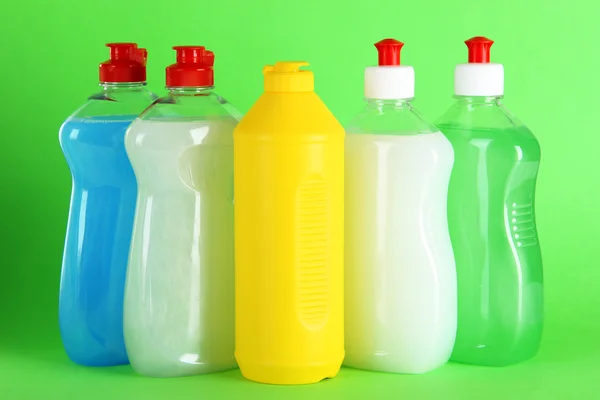 Bottles of dishwashing liquid on color background — Stock Photo, Image