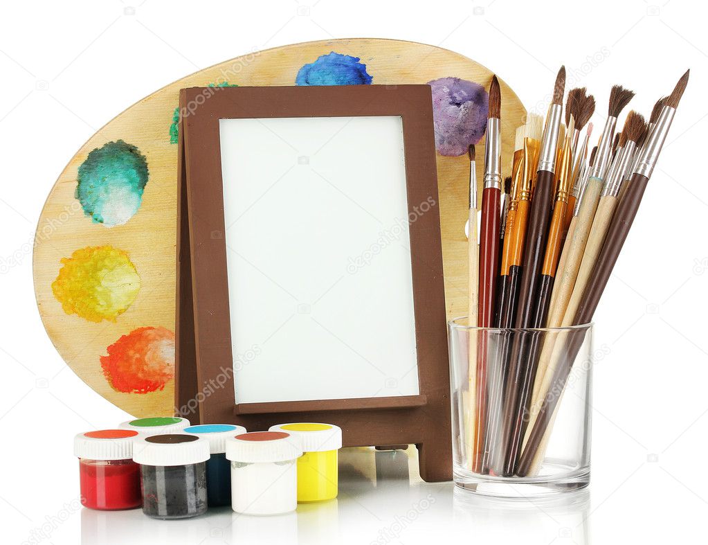 Photo frame as easel with artist's tools isolated on white