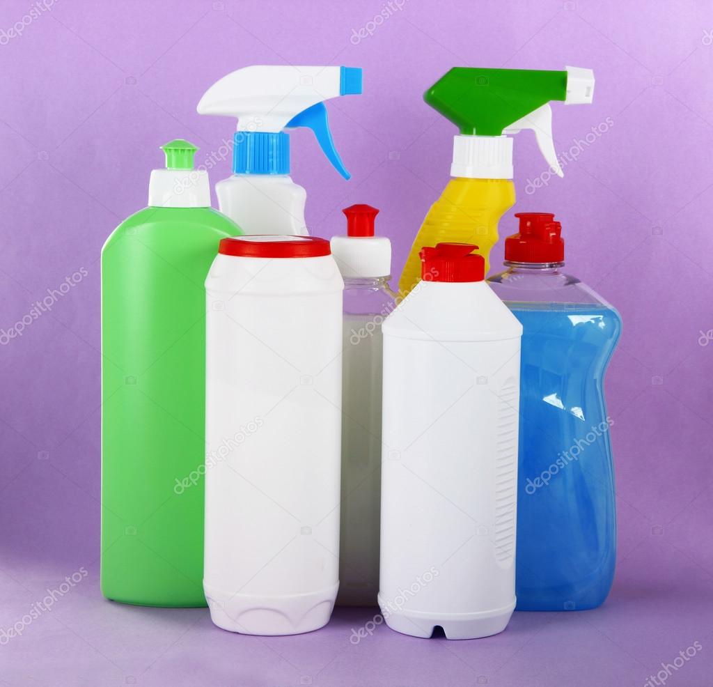 Different kinds of kitchen cleaners on color background