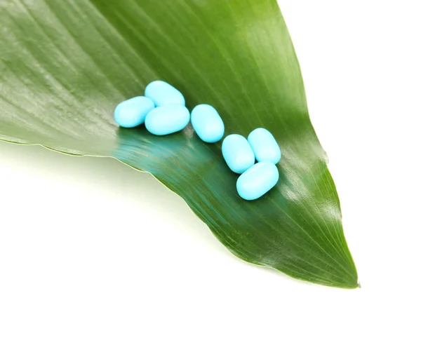 Tabletten auf grünem Blatt isoliert auf weißem Blatt — Stockfoto