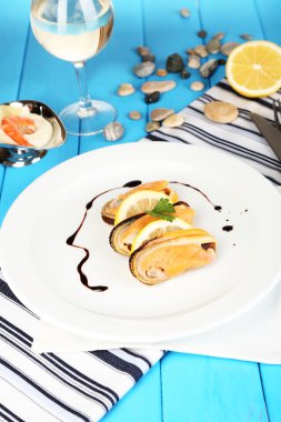 ahşap masa yakın çekim plaka üzerinde soslu midye