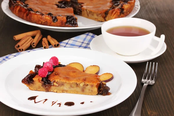 Tasty pie on plate on wooden table — Stock Photo, Image