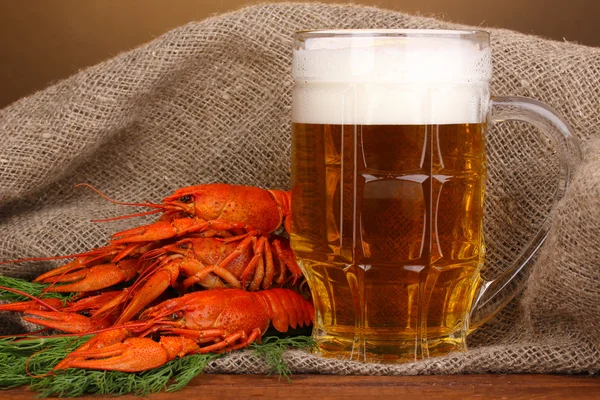 Tasty boiled crayfishes and beer on table on brown background — Stock Photo, Image