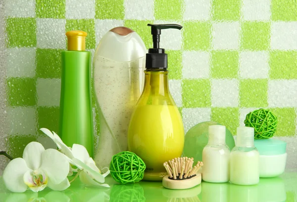 Accesorios de baño en el estante en el baño sobre fondo de pared de baldosas verdes —  Fotos de Stock