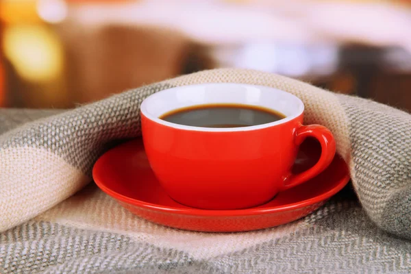 Tasse de café avec écharpe sur la table dans la chambre — Photo