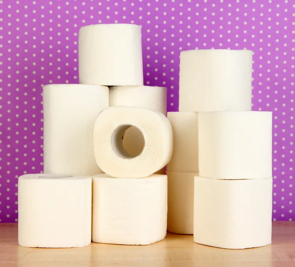 Rolls of toilet paper on purple with dots background — Stockfoto