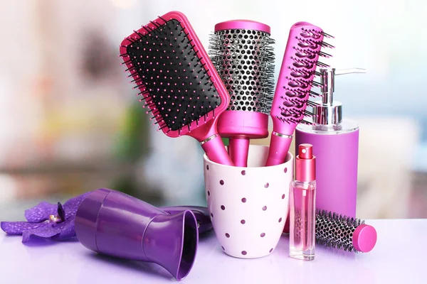 Hair brushes, hairdryer and cosmetic bottles in beauty salo — Stock Photo, Image