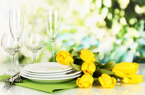 Gele tulpen en gebruiksvoorwerpen voor portie op natuurlijke achtergrond achtergrond — Stockfoto