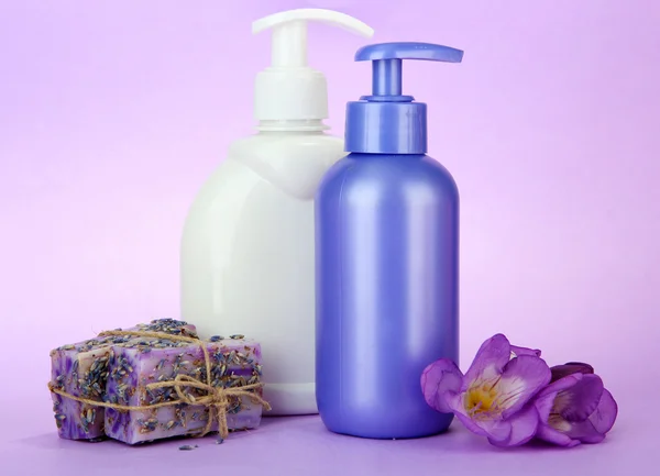 Liquid and hand-made soaps on purple background — Stock Photo, Image