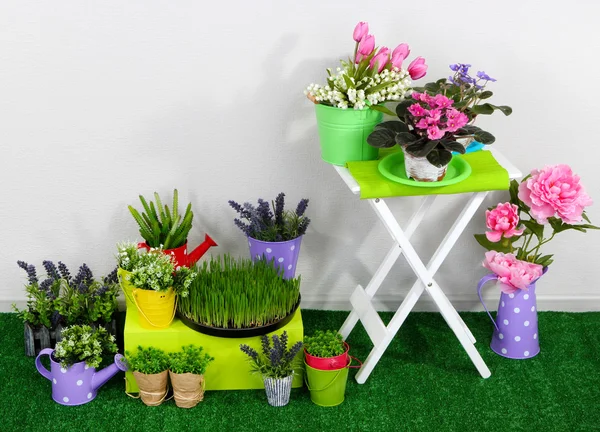 Color crate and table with decorative elements and flowers standing on grass — Stock Photo, Image