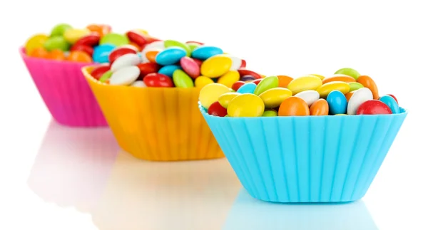 Kleurrijke snoepjes in cupcake gevallen geïsoleerd op wit — Stockfoto