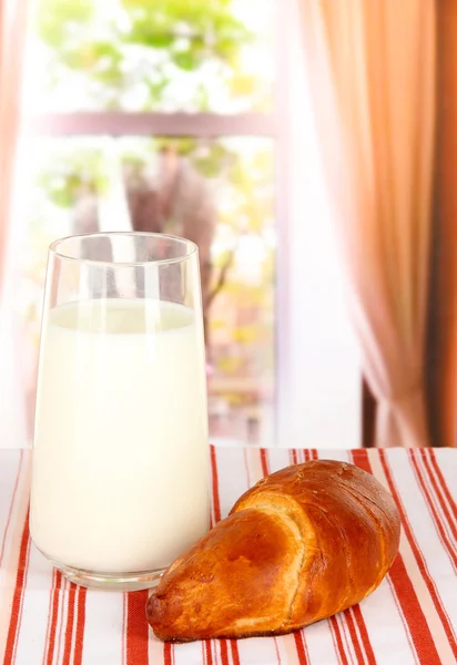 Croissant y vaso de leche en el fondo de la habitación — Foto de Stock