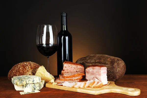 Exquisito bodegón de vino, queso y productos cárnicos — Foto de Stock