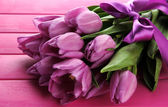 Картина, постер, плакат, фотообои "beautiful bouquet of purple tulips on pink wooden background", артикул 23188464
