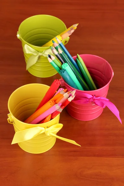 Barevné tužky a fixů v barevné kbelíky close-up na dřevěný stůl — Stock fotografie