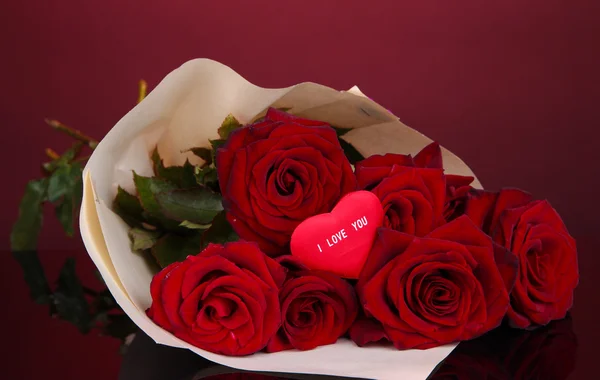 Mooi boeket van rode rozen met valentine op rode achtergrond — Stockfoto