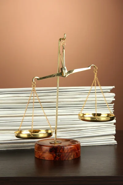 Gold scales of justice and folders on brown background — Stock Photo, Image