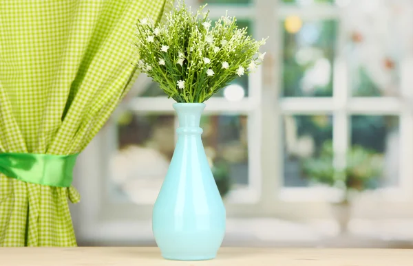 Decorative flowers in vase on windowsill — Stock Photo, Image