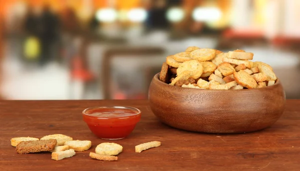 Crackers dans un bol en bois et sauce, sur fond lumineux — Photo