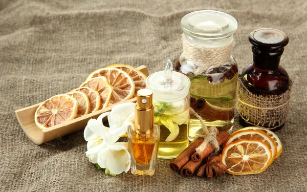 Bottles with ingredients for the perfume on burlap background — Stock Photo, Image