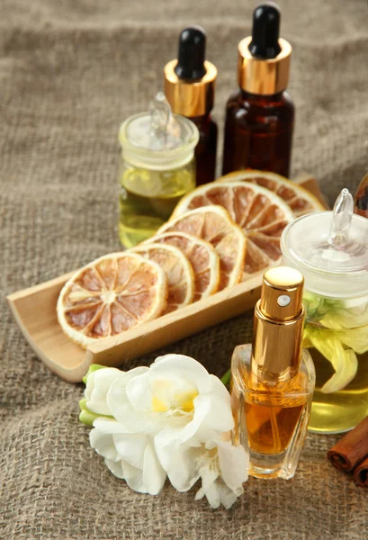 Flessen met ingrediënten voor het parfum op jute achtergrond — Stockfoto