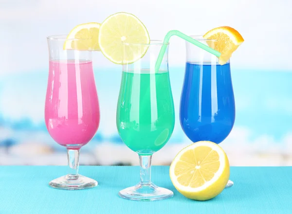 Glasses of cocktails on table near pool — Stock Photo, Image