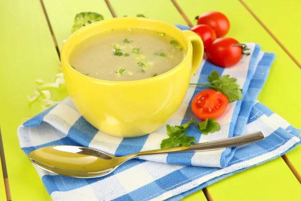 Sopa de dieta com verduras em xícara em mesa de madeira verde close-up — Fotografia de Stock