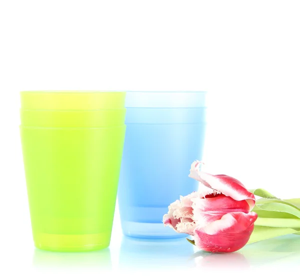 蓝色和绿色的塑料杯子和勺子，孤立白底粉红郁金香 — 图库照片