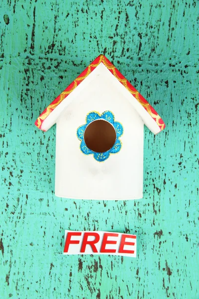 Decorative nesting box and sign on color background — Stock Photo, Image