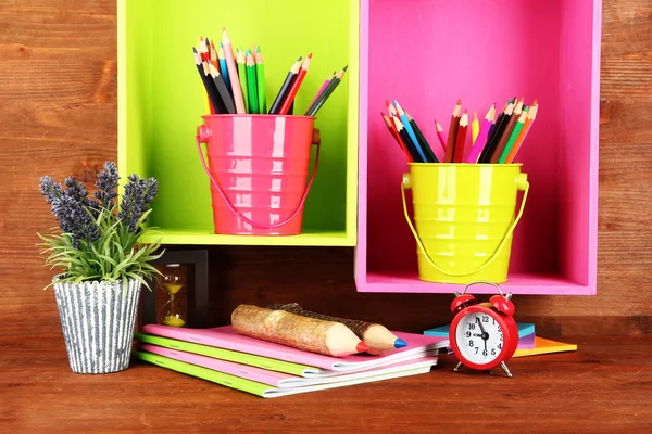 Colorful pencils in pails on shelves on wooden background — Stock Photo, Image