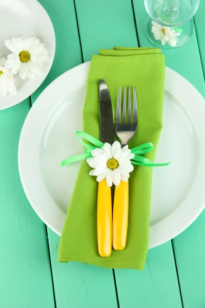 Kniv och gaffel insvept i Servett, på plattan, på färg trä bakgrund — Stockfoto