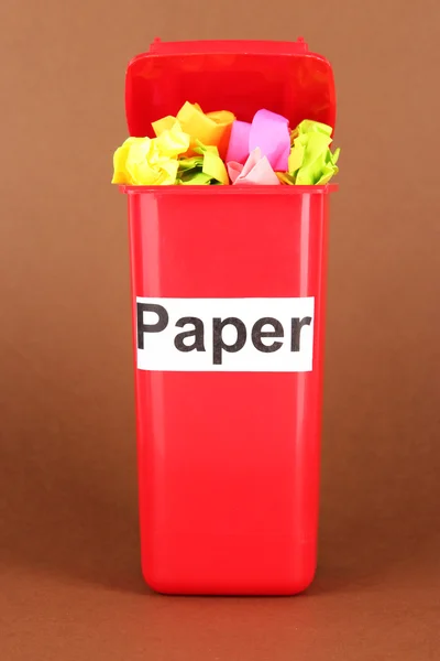 Recyklace bin s papíry na hnědé pozadí — Stock fotografie